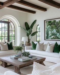 a living room filled with white couches and green pillows