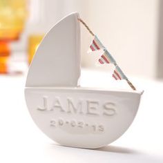 a sailboat shaped ornament with the name james on it's side