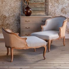 an old fashioned chair and footstool in front of a dresser with a vase on it