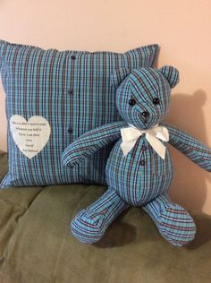 a blue plaid teddy bear sitting next to a pillow on a couch with a poem written on it