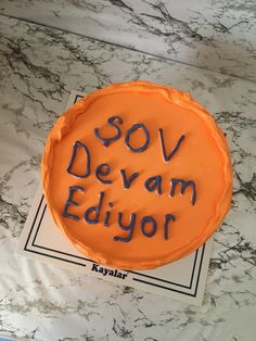 an orange cake with writing on it that says sov devam ediyor