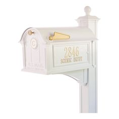 a white mailbox with gold lettering on it