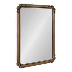 a mirror that is sitting on top of a white wall and has an ornate frame around it