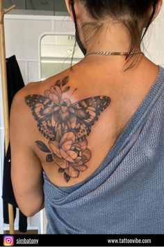 a woman with a butterfly tattoo on her upper back shoulder and flowers around the neck