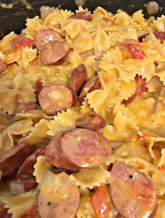 a pan filled with pasta and sausages on top of it