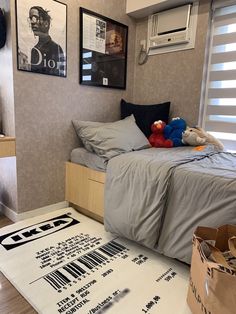 a bed room with a neatly made bed and posters on the wall