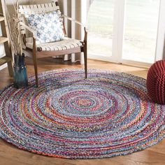 a round rug in the middle of a living room with a chair next to it