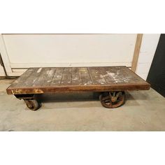 an old wooden table with wheels on it