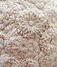 a close up view of an intricately detailed sculpture made out of white plastic flowers