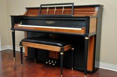 an upright piano sits in the corner of a room