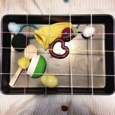 a black tray filled with toys on top of a bed