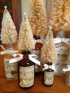 several bottles with christmas trees in them sitting on a table next to music notes and decorations