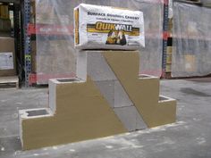 cement blocks stacked on top of each other in front of some pallets with construction materials