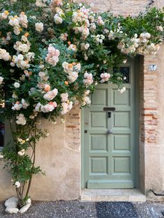 a green door with flowers growing over it