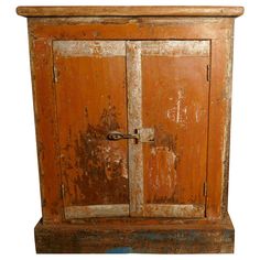 an old wooden cabinet with rusted paint on the doors and bottom part of it