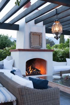 an outdoor living area with a fireplace and wicker furniture