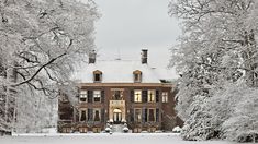 a large brick building surrounded by trees covered in snow