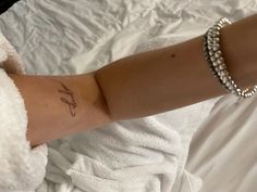 a woman's arm with a small tattoo on it