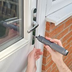 a person opening a door with an electronic device in front of him and another hand holding the door handle