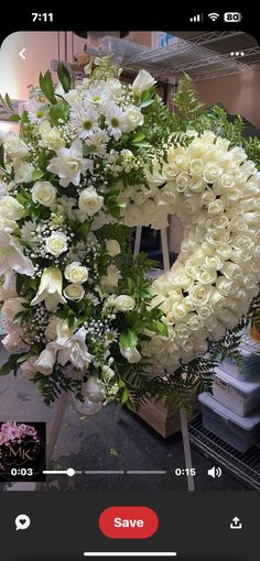 white flowers arranged in the shape of a heart on a stand with an instagram button