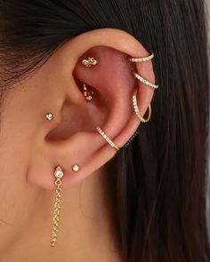 a woman's ear with three different types of piercings