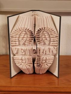 an open book with folded pages on top of it