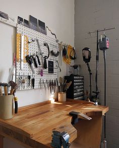 a workbench with tools hanging on the wall