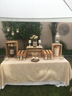 the table is set up with candles and vases for an outdoor wedding reception or party