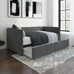 a modern daybed with storage underneath it in a white and black bedroom area, next to a large window