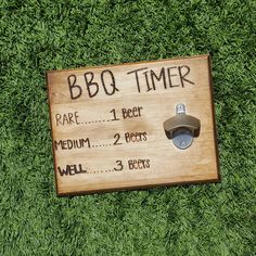 a wooden sign that says bbq timer on it's side in the grass