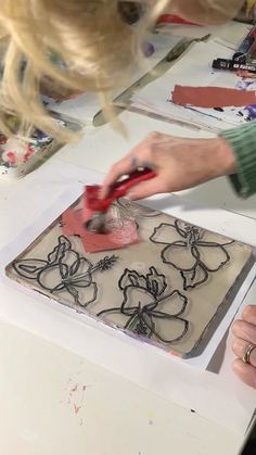 a woman is using a pair of scissors to decorate a cake