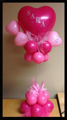 a pink balloon with the word sara on it and some balloons in front of it