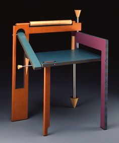 an artistic desk made out of wood and painted blue, pink, orange and yellow