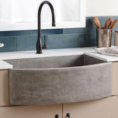 a kitchen sink made out of concrete in front of a counter top with utensils