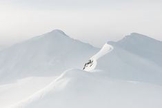 a person riding skis on top of a snow covered slope