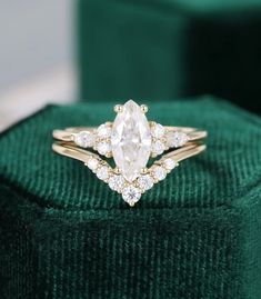 a diamond ring sitting on top of a green velvet box