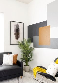 a living room with a couch, chair and potted plant in front of the window