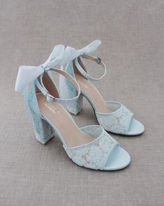 "Fun and flirty lace block heel sandals with added satin back bow. Perfect for weddings, parties, or any special occasion. DETAILS: HEEL HEIGHT: 3.6 inches COLORS AVAILABLE: Ivory, White and Light Blue UPPER: Synthetic upper and lining MATERIALS: Manmade outsole STYLE NAME: FAITH  SIZE FIT: RUNS LARGE  Not sure of which size to purchase? Shoes measurements are as follow: (Please note measurements taken the length of inside of shoe from toe to heel) SIZE 5 - 9.25\" SIZE 6 - 9.50\" SIZE 7 - 9.75\" Open Toe Sandals With Satin Bow For Wedding, Wedding Ankle Strap Sandals With Satin Bow, High Heel Sandals With Satin Bow For Wedding, Wedding Sandals With Satin Bow And Open Heel, Wedding Heels With Satin Bow Open Heel, Wedding Heels With Satin Bow And Open Heel, Wedding Heels With Satin Bow, Summer Lace Heels With Block Heel, Summer Lace Block Heel Heels