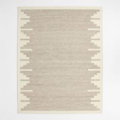 a beige and white rug with lines on the bottom, in front of a white wall