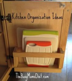 the kitchen organization ideas are organized with cutting boards and plastic utensils in a cabinet