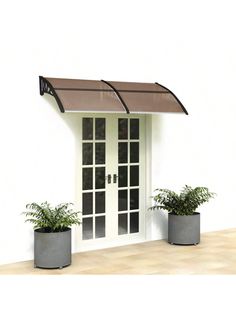 two planters with plants are in front of a white door that has an awning over it