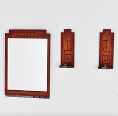 three wooden mirrors mounted to the side of a wall