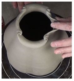 someone is making a vase out of clay with their hands on the top and bottom