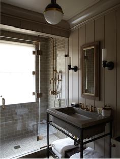 a bath room with a sink a mirror and a shower head mounted to the wall