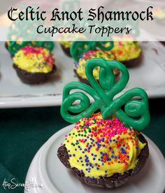 some cupcakes with green frosting and sprinkles on them are sitting on a plate