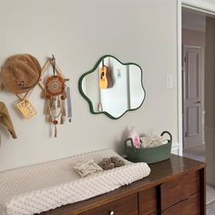 a baby's crib in the corner of a room next to a mirror and coat rack