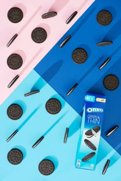 an oreo cookie next to some oreos on a blue and pink background