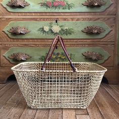 a white basket sitting on top of a wooden floor next to a dresser with drawers