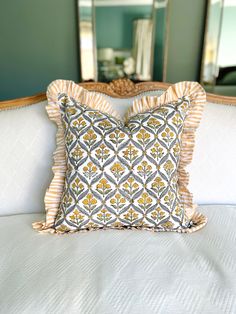 a white bed topped with pillows and a mirror