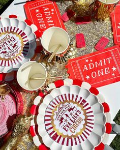 red and white paper plates with gold foil on them sitting on the ground next to other decorations